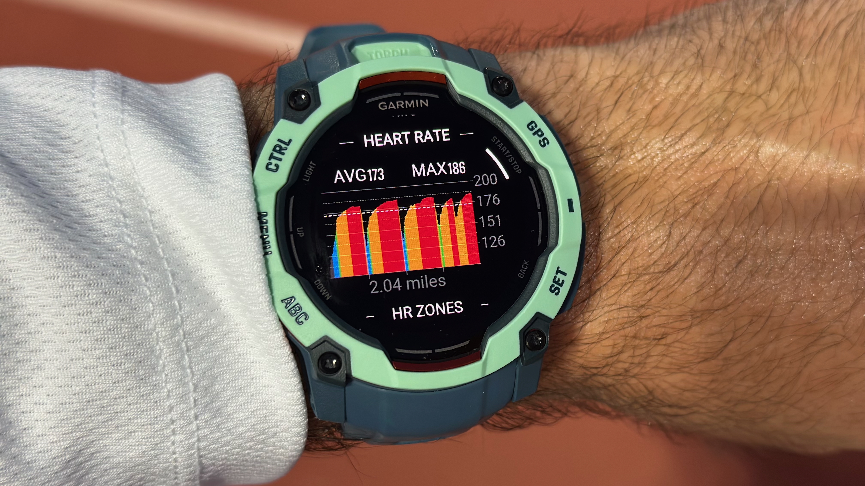 A post-run heart rate graph showing the runner's average and max heart rate across a two-mile track workout, with most heart rates in zone 4 (orange) or zone 5 (red).